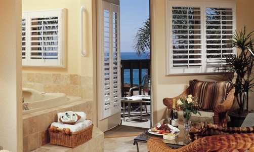 Plantation shutters on casement windows in a tropical room.